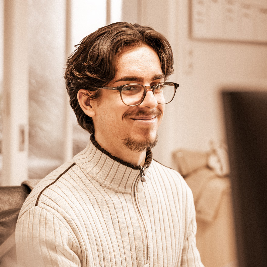 Arbnor Gjaka, Auszubildender bei eest GmbH – Atelier für Messe, Raum und Kommunikation, Projekte und Mediengestaltung, vor den Buchstaben des Unternehmens
